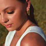 Side of Burdlife Model's head displaying 3 earrings including the Luxe Oval Hoops, the Refined Single Chain Earring and the Modish Triple Crystal Studs. 