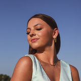 Model wearing 3 earrings including the Luxe Oval Hoops, the Refined Single Chain Earring and the Modish Triple Crystal Studs. 